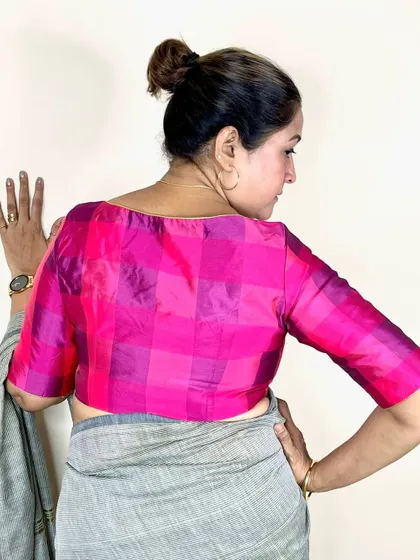 My Pink Checks Blouse is a blend of tradition and trend. Here, it's paired with a simple grey saree for a modern, elegant look.