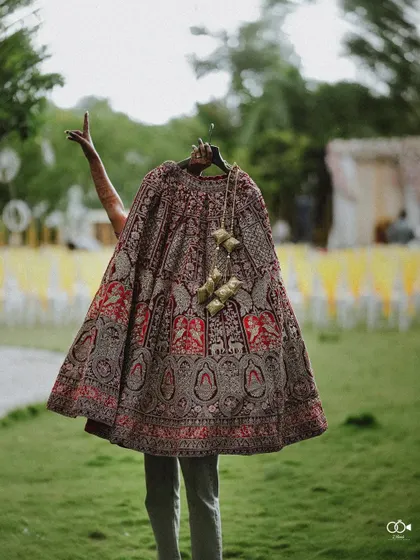 An artistic shot of the bride holding up her heavy wedding lehenga before putting it on.