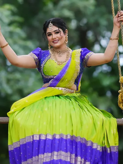 A playful shot of a model on a swing, showcasing the full traditional attire with our rental jewellery.