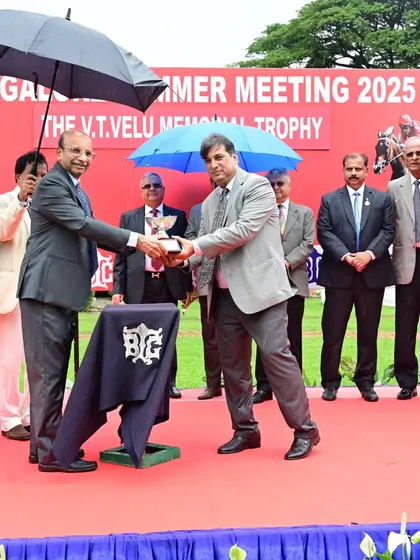 Mr. V. Vijayendra Velu presents the memorial trophy to the owners of Odysseus on a rainy day.