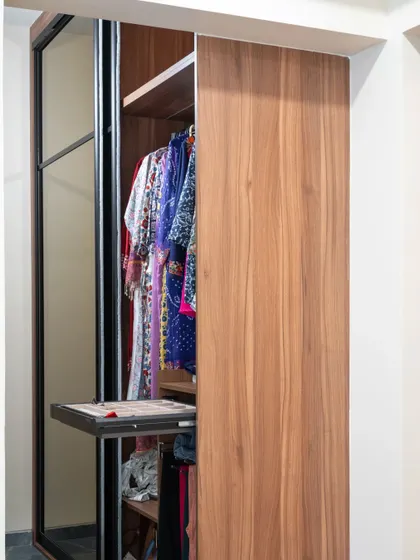 This sliding wardrobe features a pull-out accessory tray, providing a dedicated and organized space for smaller items like watches, belts, and jewelry.