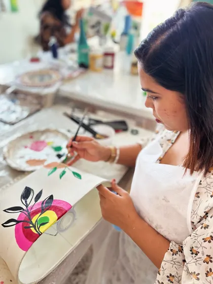 A participant adding details to her floral lampshade design.