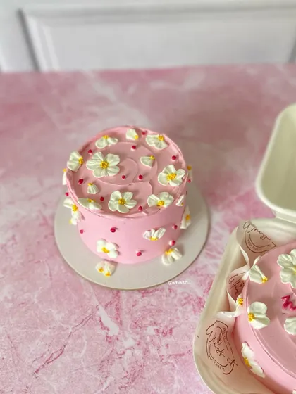 The pink daisy mini cake and its matching bento cake, ready to be packed. This duo is perfect for sharing or for enjoying a little extra sweetness.