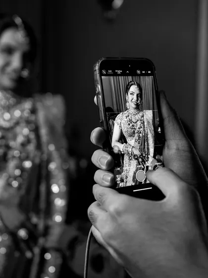 Capturing the final look on my phone. This black and white shot shows a behind-the-scenes moment of me documenting the bride's complete look before she steps out.