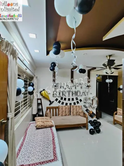 A classic 50th birthday decoration for a home celebration, using black, white, and silver balloons and foil letter banners.