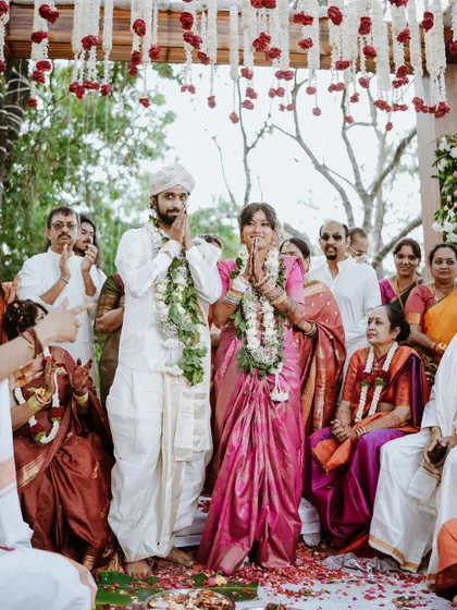 The couple stands together to greet their guests after the ceremony, their faces beaming with happiness.