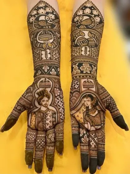 A clear, high-contrast image of a bride and groom portrait. The dark, natural henna stain makes the detailed figures and patterns stand out beautifully.