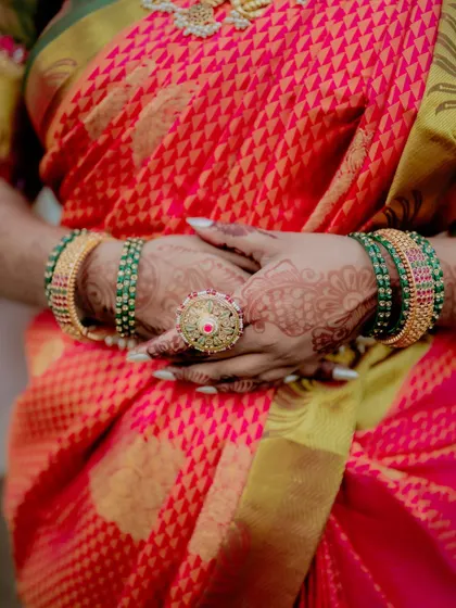 A close-up of the bride's hands, showcasing her intricate henna, colorful bangles, and a statement ring. These details are an essential part of the Indian bridal look.