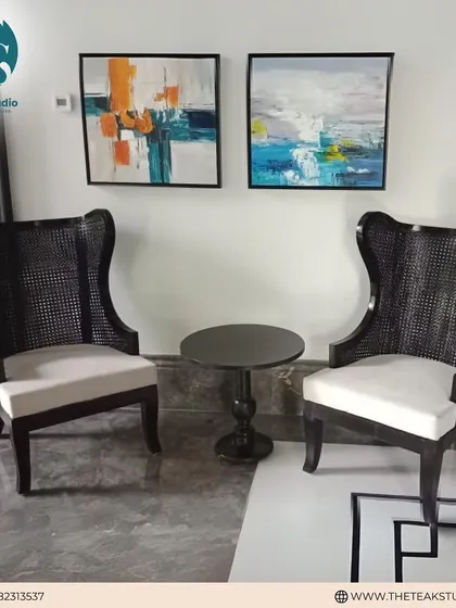 A pair of stately high-back chairs with caned backs and plush white seat cushions. The dark wood finish and classic design make them a sophisticated addition to a formal living room or entryway.