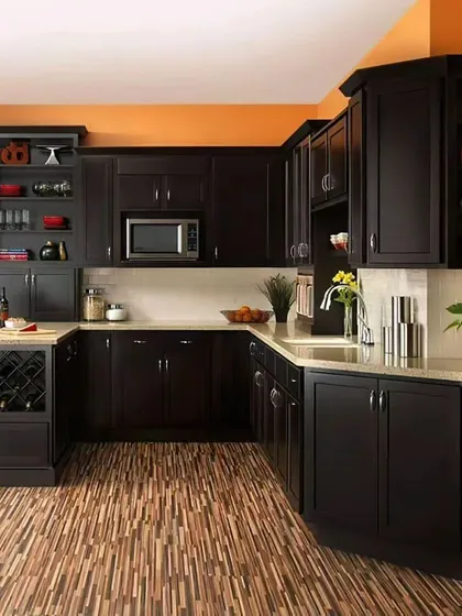 A traditional U-shaped kitchen with dark wood cabinets and an orange accent wall. The layout includes a peninsula with a built-in wine rack, adding extra functionality.
