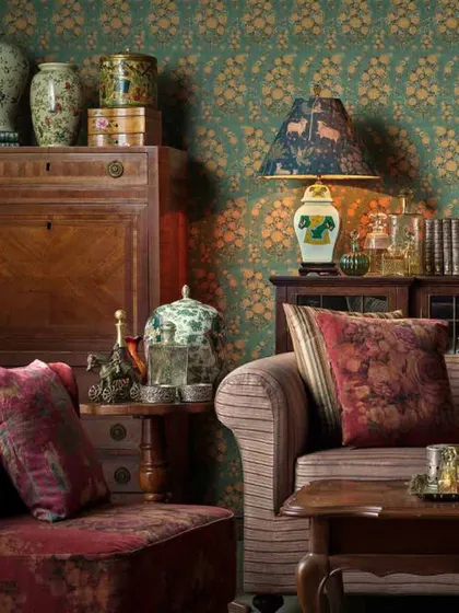 Another view of the luxurious room decorated with Sabyasachi wallpaper, showcasing how it pairs with traditional wooden furniture and rich velvet upholstery.
