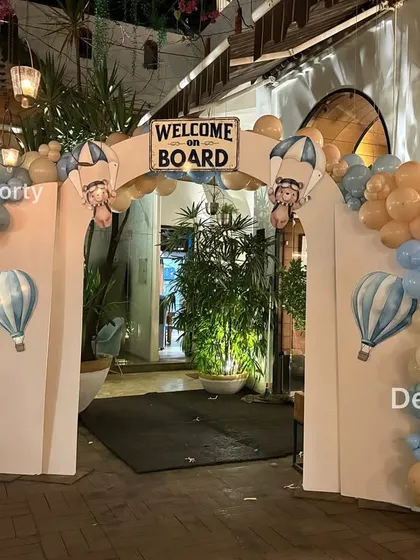 The 'Welcome on Board' entrance arch, decorated with blue and beige balloons, ready to greet party guests.