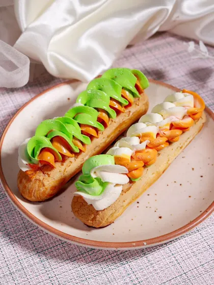 To celebrate Independence Day, we created these Tricolour Eclairs. The light choux pastry is filled with cream and topped with colourful frosting.