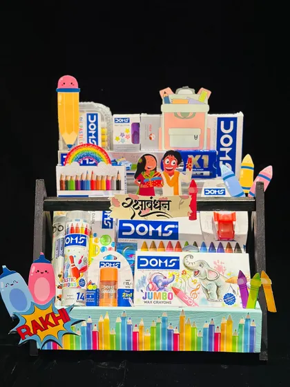 This stationery-themed Rakhi hamper is perfect for a creative sibling. It’s fully loaded with Doms art supplies, from crayons to color pencils, making it a thoughtful and useful gift for the artist in your family.