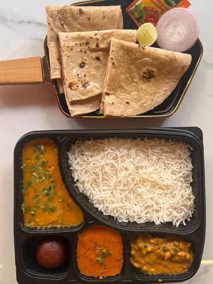 A classic North Indian thali in a box. This option includes dal, two vegetable preparations, paneer, rice, and rotis, making it a wholesome and traditional meal choice for any event.