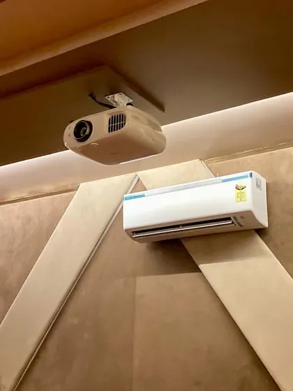 A look at the ceiling and rear wall of the Firozabad project, showing the ceiling-mounted Epson projector and strategically placed surround sound speakers for immersive audio.