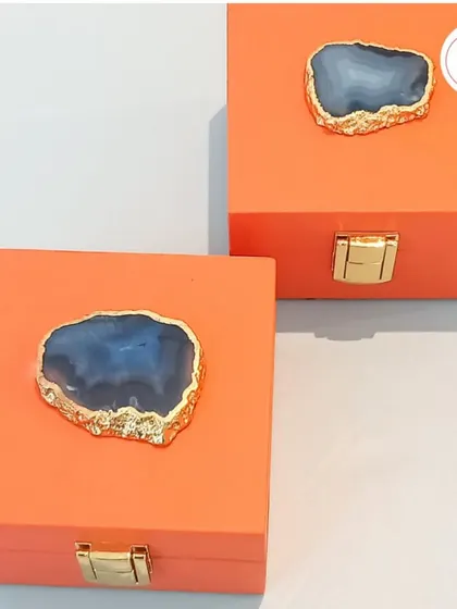 For a modern and earthy aesthetic, these orange boxes are topped with a beautiful agate stone, making each favor box a unique piece of art.