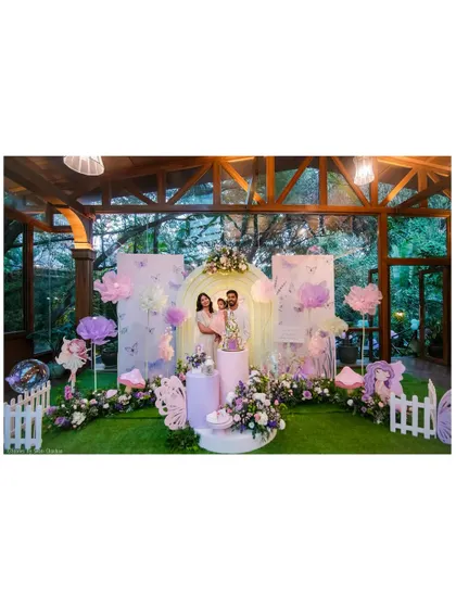 A family portrait in our fairy wonderland. This wide shot shows the complete setup with a large arched backdrop, butterfly accents, and lush floral arrangements, creating a perfect photo opportunity.