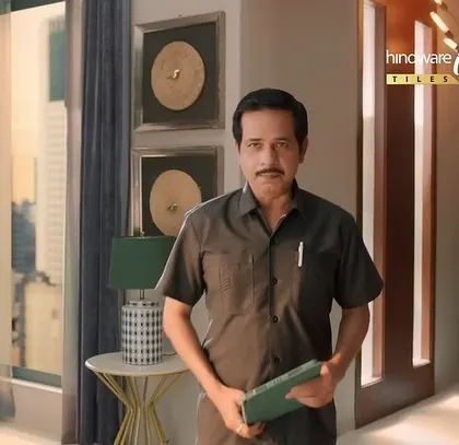A still from the Hindware ad, where the character is standing in a beautifully designed home. His simple attire contrasts with the luxurious surroundings.