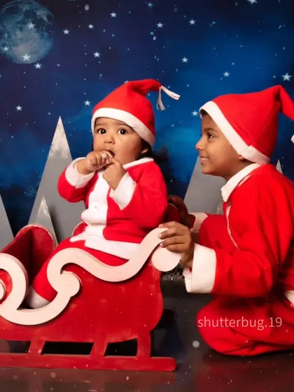 A precious moment between two brothers dressed as Santa, getting ready for a ride in the sleigh.