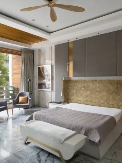 The master bedroom in the Screen House is spacious and elegantly furnished with a grey and gold palette. It opens to a balcony that offers refreshing green views, making it a bright and inviting space.