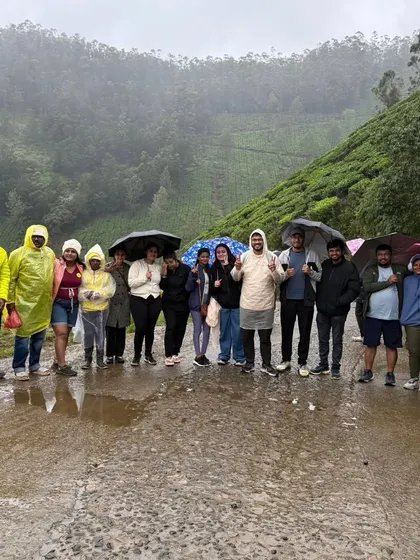 A group with umbrellas and raincoats, fully embracing the rainy weather in Munnar. The monsoon season brings out the best in these green landscapes.
