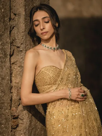A 'Symphony of Golden' look from a photoshoot, featuring a stunning gold saree and elegant jewelry.