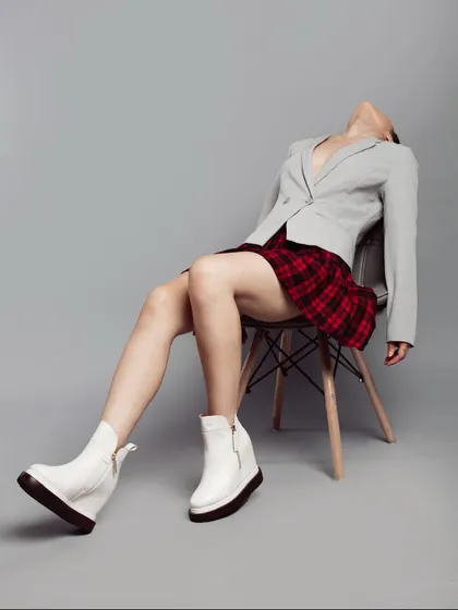 Lookbook styling for a shoe label, where I paired chunky white platform boots with a plaid skirt and a grey blazer. The pose and composition create a rebellious, preppy-punk aesthetic that is both playful and edgy.