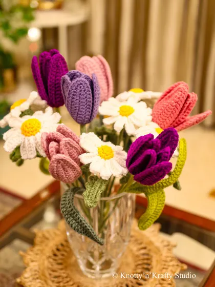 I created this bouquet of crochet tulips and daisies to offer blooms that last forever. Each flower is stitched with care, bringing a mix of vibrant purples, pinks, and fresh whites that can brighten any room, any day of the year, without ever wilting.