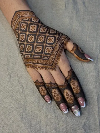 A beautiful example of 'jaal' or grid-based design. The repeating floral pattern creates a stunning, cloth-like effect on the back of the hand.