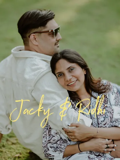 A relaxed and stylish pre-wedding portrait. The couple's comfortable pose and the clean, simple background create a modern and effortlessly chic image.