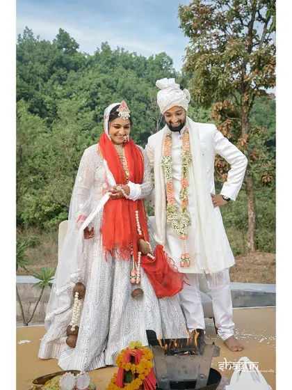 A posed shot of the couple after their pheras, standing by the sacred fire, officially husband and wife.
