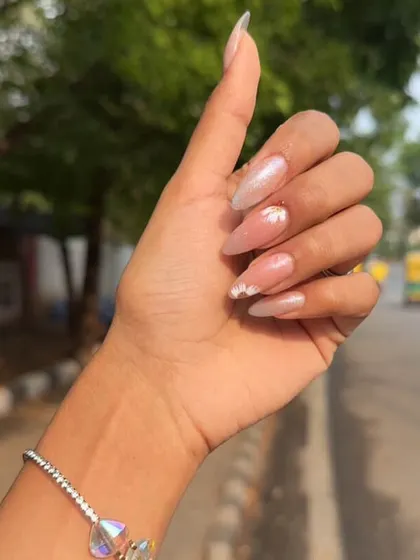 A delicate and dreamy set. We used a shimmery, translucent base and hand-painted tiny, simple daisies for a "your nails but better" look.