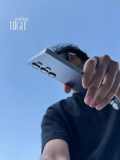 A dynamic shot of me holding my phone, my primary creative tool. This angle conveys a sense of power and action, representing the 'run and gun' nature of my work.