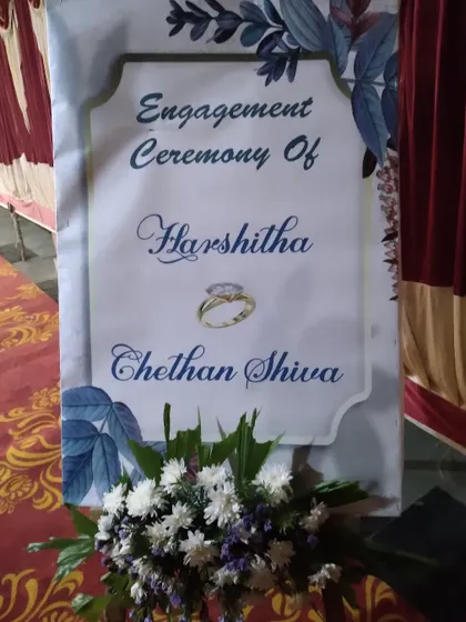 A classic welcome board for an engagement ceremony, featuring the couple's names and a simple floral design.