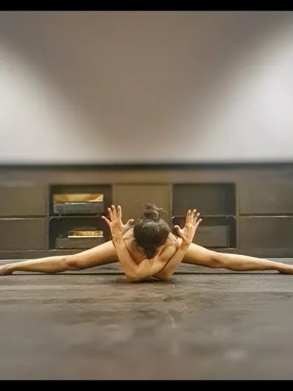A deep forward fold with a twist and crossed arms. This posture stretches the hamstrings and inner thighs while also opening up the shoulders and upper back.