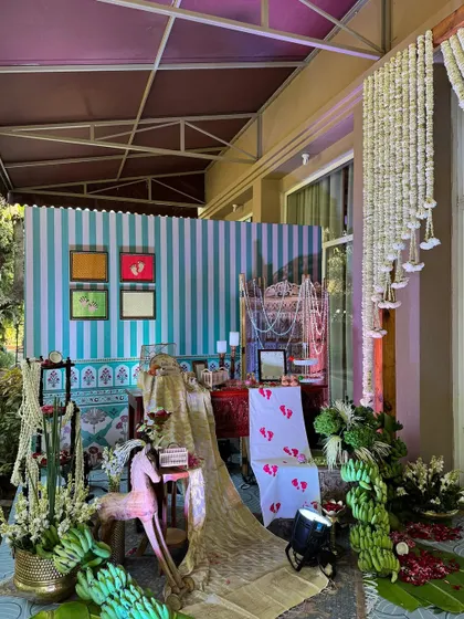 A wide view of one of the event's beautifully styled nooks, combining traditional fabrics, floral arrangements, and artistic elements.