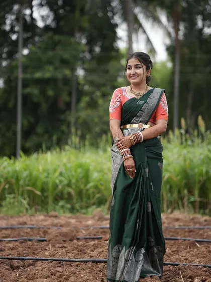 The bride posing in a field, the natural backdrop highlighting the beautiful colors of her outfit.