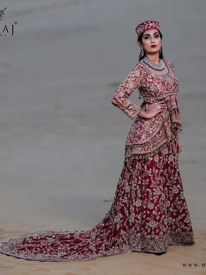 A side view of the rose-gold peplum top with a long tail, showcasing the intricate zardozi work and the magnificent dupatta with a zari-worked border.