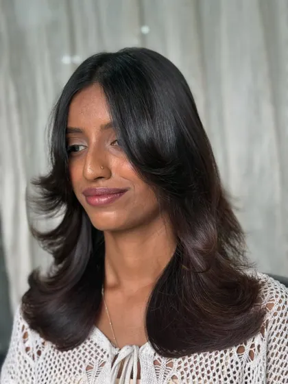 A side view of this refreshing cut. The soft, face-framing layers and healthy, glossy finish give the hair a new lease on life.