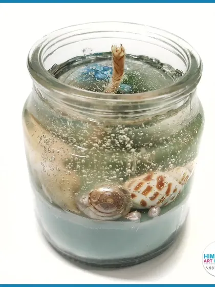 A beach-themed gel candle with sand and seashells. A perfect way to capture summer memories in a beautiful, handmade decor piece.