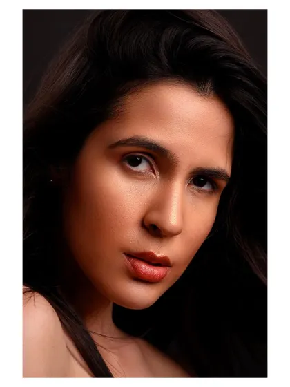 A close-up beauty shot with a focus on the model's direct gaze. The simple composition and clean lighting make this a powerful and engaging portrait.
