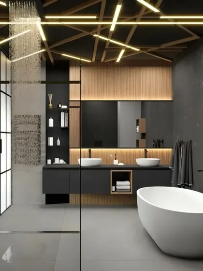 Experience spa-like luxury in your own home with our custom bathroom designs. This space showcases a freestanding bathtub, a walk-in rain shower, and a bold combination of dark stone and wood, all highlighted by dramatic geometric ceiling lights.