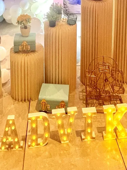 Personalized marquee letters spelling 'AADVIKA' add a special touch to this Frozen-themed party. I use corrugated plinths and decorative boxes to display props and create different levels in the decor.