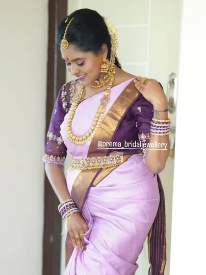 A candid shot showing the beautiful fall of the long coin necklace against her lavender silk saree.
