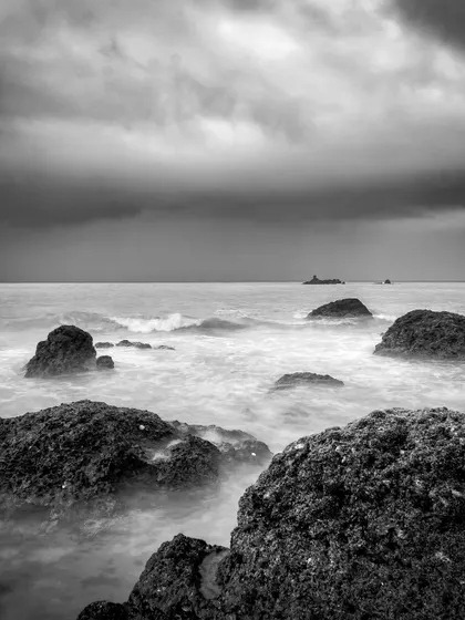 A moody, black and white long exposure of the sea at Gokarna, taken in 2017. Monochrome brings out the textures and drama of the cloudy sky and churning water.