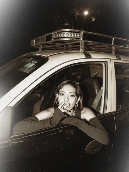 A moody, atmospheric shot with a vintage taxi. The sepia tone and the model's expression create a nostalgic, film-noir vibe.