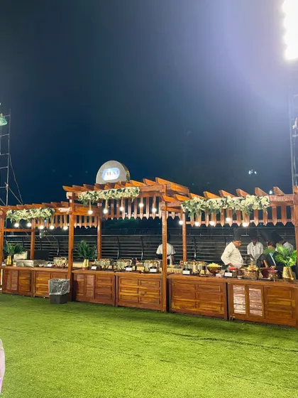 The rustic wooden setup for the Thai food station, adorned with floral arrangements.