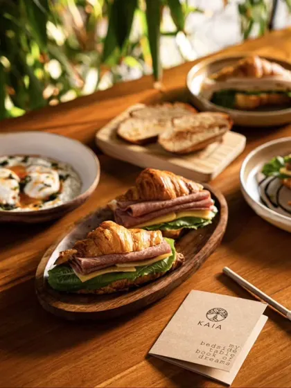 A shot focusing on the croissant sandwiches at Kaia Goa, with other breakfast items blurred in the background to create depth.