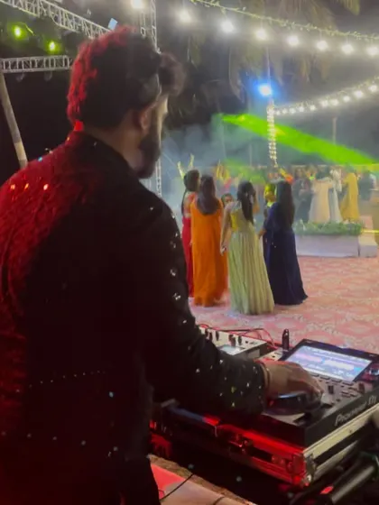 From my perspective behind the decks at a vibrant outdoor wedding. I love watching the dance floor fill up as I mix the perfect tracks for the celebration.